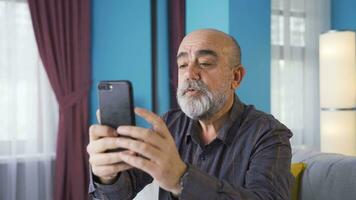 feliz velho homem falando Facetime em a telefone. video