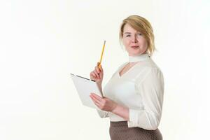 Portrait mature businesswoman looking at camera, holds clipboard and pointing up finger with pencil photo