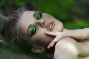 Closeup portrait of authenticity woman with short hair and bright make-up looking at camera photo