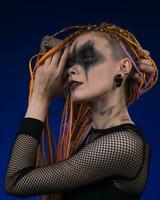 Female with horror black stage makeup painted on face and without dangerous dreadlocks hairstyle photo