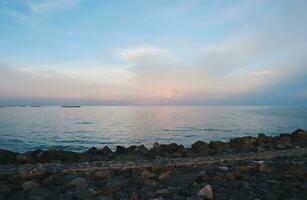 paisaje de mar y playa durante puesta de sol noche hora con vainilla cielo foto