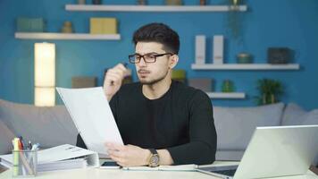 Thoughtful young man working on paperwork. video