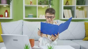 Little boy working on his father's laptop and file. He dreams of becoming a businessman. video