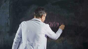 Male doctor writing Euthanasia on the blackboard. video