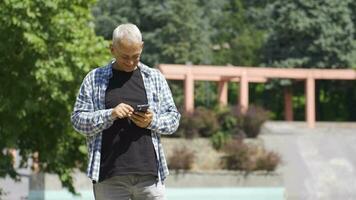 homem usando social meios de comunicação em a telefone ao ar livre. video
