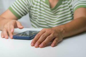 Pointing finger at mobile phone screen close up. Close-up of beautiful asian woman holding, using and looking at smartphone. photo