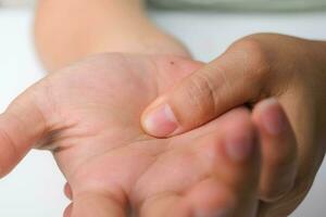 mujer con muñeca dolor, entumecimiento o de mano túnel síndrome, artritis, neurológico enfermedad. de cerca de mujer mano participación un doloroso articulación. foto