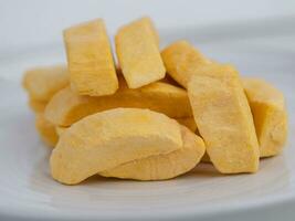 Healthy freeze dried fruits. Freeze-dried mango in plate on table, close-up. photo