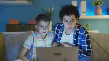 Two young men making a video call on a laptop.