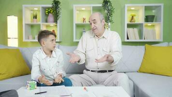 Grandfather motivates his grandson to his lesson. video