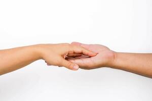 Hands of man and woman reaching to each other. Two people holding hands on white background. That can mean helping, caring, protecting, loving, caring and world peace concept. photo