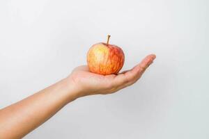 Hand holding red apple isolated on white background. Ripe red apple in human hand. photo