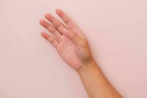 Close up of male hand reaching out ready to help or receive isolated on pink background. Helping hand outstretched for salvation. photo
