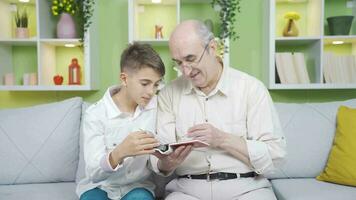 abuelo examina su antiguo foto álbum con franqueza con su nieto. video