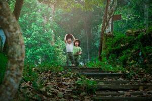 The sisters use the map on their smartphones and enjoy hiking together. Family on a hiking adventure through the forest. Family spending time together on vacation. photo