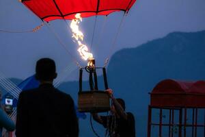 Gas burner blowing up hot air balloon. Slow motion scene of flames rising and inflating hot air balloons. Preparing for a balloon flight photo