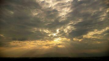 hora lapso de el hermosa paisaje de el puesta de sol cielo con el dorado rayos de el Dom en contra el antecedentes de el silueta de el montaña paisaje. natural paisaje antecedentes. foto