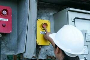 retrato de un ingeniero eléctrico asiático profesional que enciende los interruptores. foto