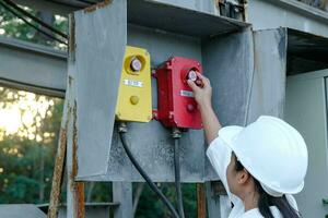 retrato de un ingeniero eléctrico asiático profesional que enciende los interruptores. foto