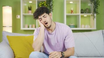 Sleepy young man at home yawning. video