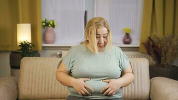 fetma kvinna ser på henne mage. video