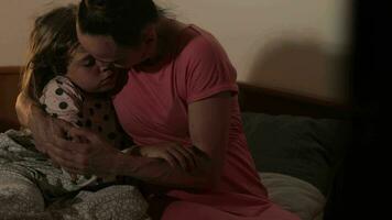 a woman and a child are hugging in bed video