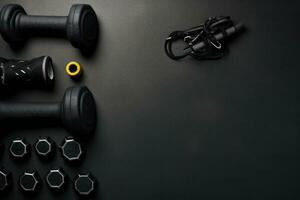 Set of black dumbbells on black background with copy space, Fitness background, black sport equipment for training, copy space, top view, AI Generated photo