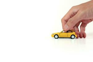 Hand holding a yellow toy car isolated on white background. After some edits. photo