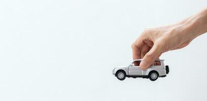 Hand holding a toy car isolated on gradient background. After some edits. photo