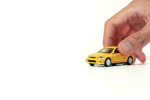 Hand holding a yellow toy car isolated on white background. After some edits. photo