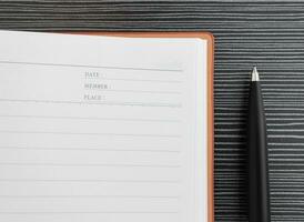 A pen and book placed on textured table. After some edits. photo