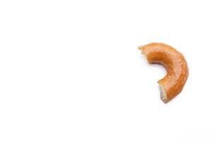 Bitten glazed donut isolated on white background. After some edits. photo