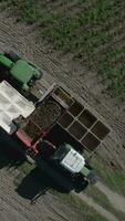 an aerial view of a tractor and trailer loading a truck with potatoes video