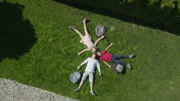 drei Menschen Verlegung auf das Gras im Vorderseite von ein Haus video