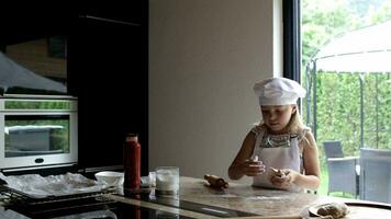 une Jeune fille dans une chef chapeau fabrication pâte video