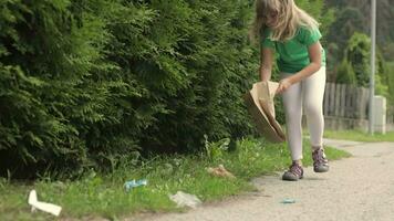 a little girl is picking up trash on the side of the road video