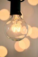 Incandescent light bulb with christmas round bokeh. photo