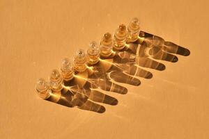 Glass ampoules on a beige orange background. photo