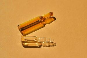 Glass ampoules on a beige orange background. photo