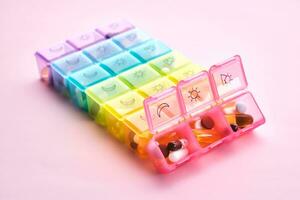 Bright pill box with different pills and vitamins. photo