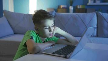 Little boy falling asleep looking at laptop. video