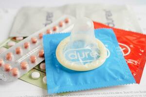 Pregnancy test with birth control pills and condom for female on calendar, ovulation day. photo