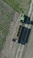 an aerial view of a tractor and trailer loading a truck with potatoes video