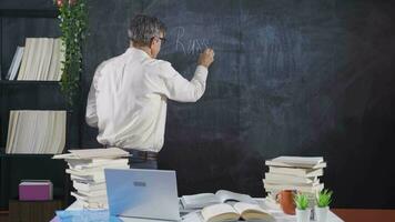 Historian man writing History of Russia on blackboard. video