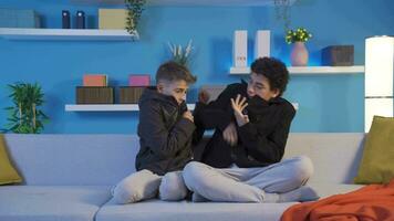 Two brothers, cold and shivering at home, hug each other. video