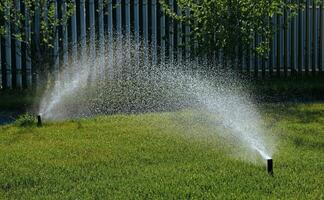 Automatic garden irrigation system watering lawn with adjustable head. Automatic equipment for irrigation and maintenance of lawns, gardening. photo