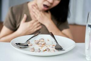 woman having peanut allergy reaction with shortness of breath or wheezing after eating meal photo