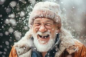 A old man in winter clothes plays in the snow in front of house photo