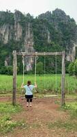 donna giocando swing nel parco a campagna di Tailandia video