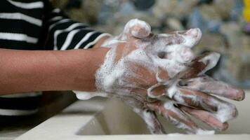 young man washing hands with soap warm water video